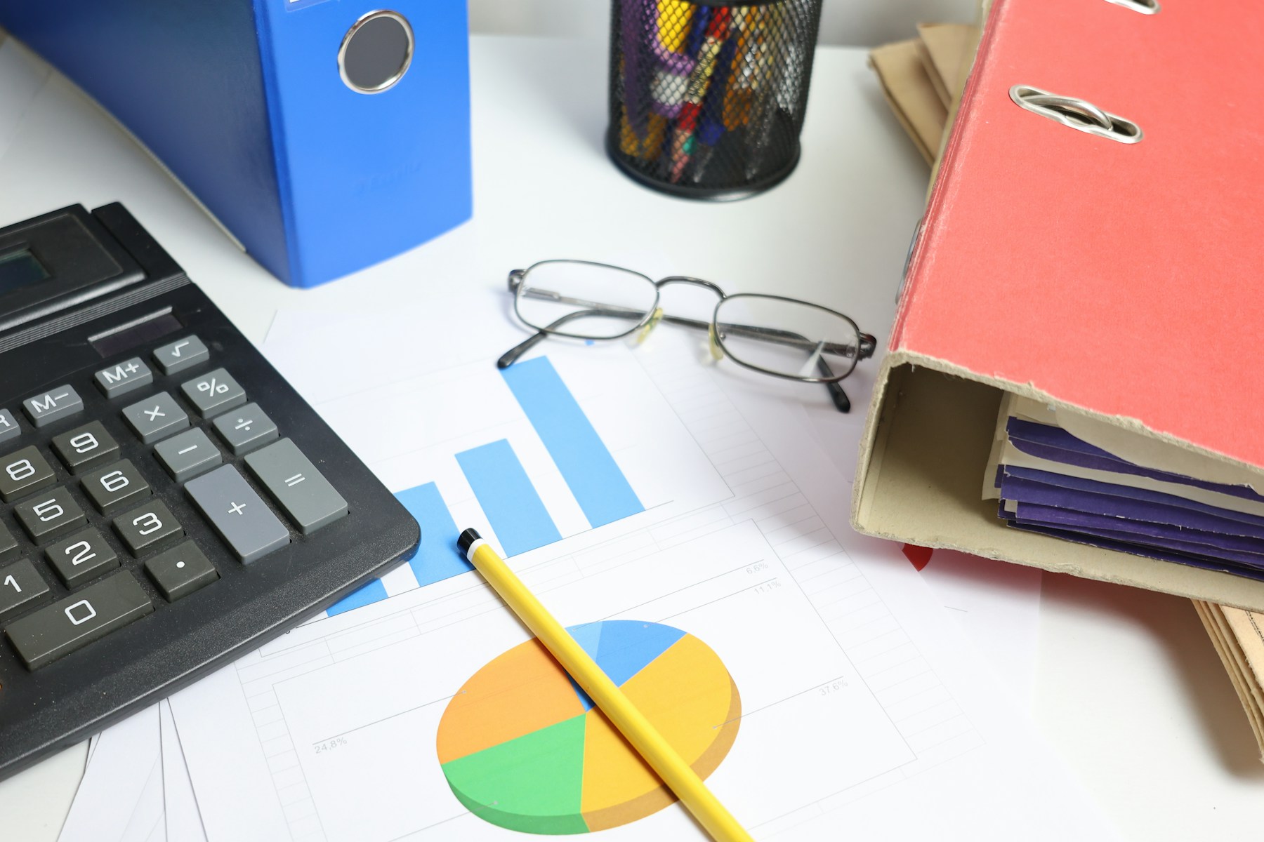 Calculator, charts, and planning documents arranged on a working desk