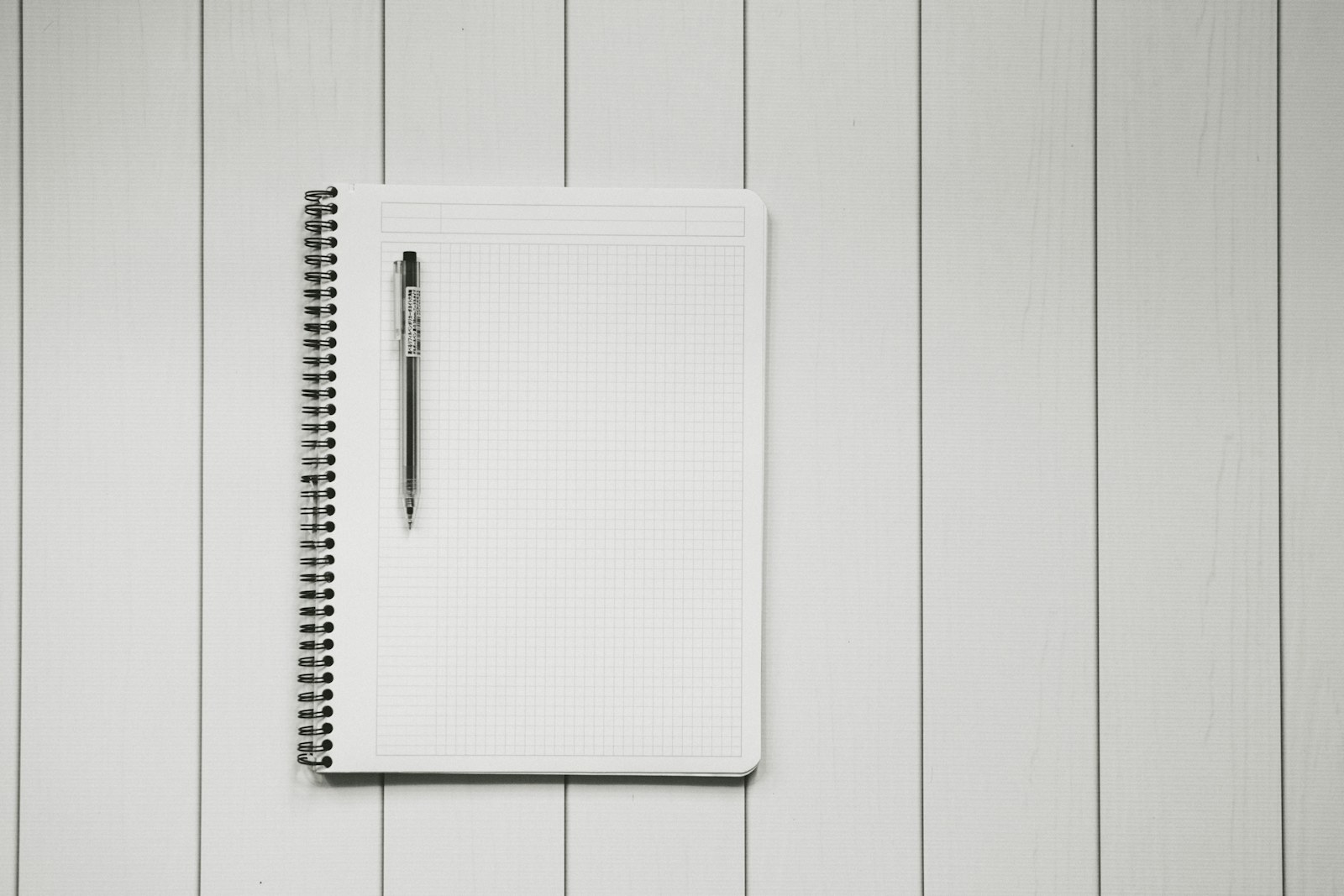 Monochrome graph notebook and pen prepared for structured planning