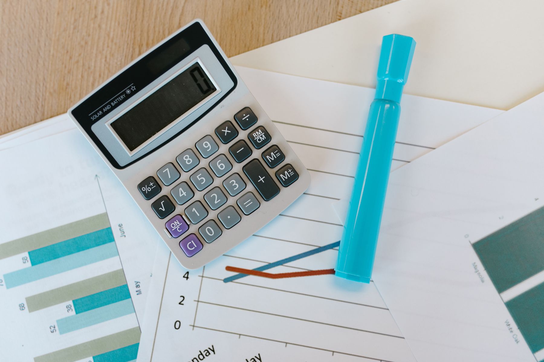 Calculator, marker, and performance charts arranged on a desk
