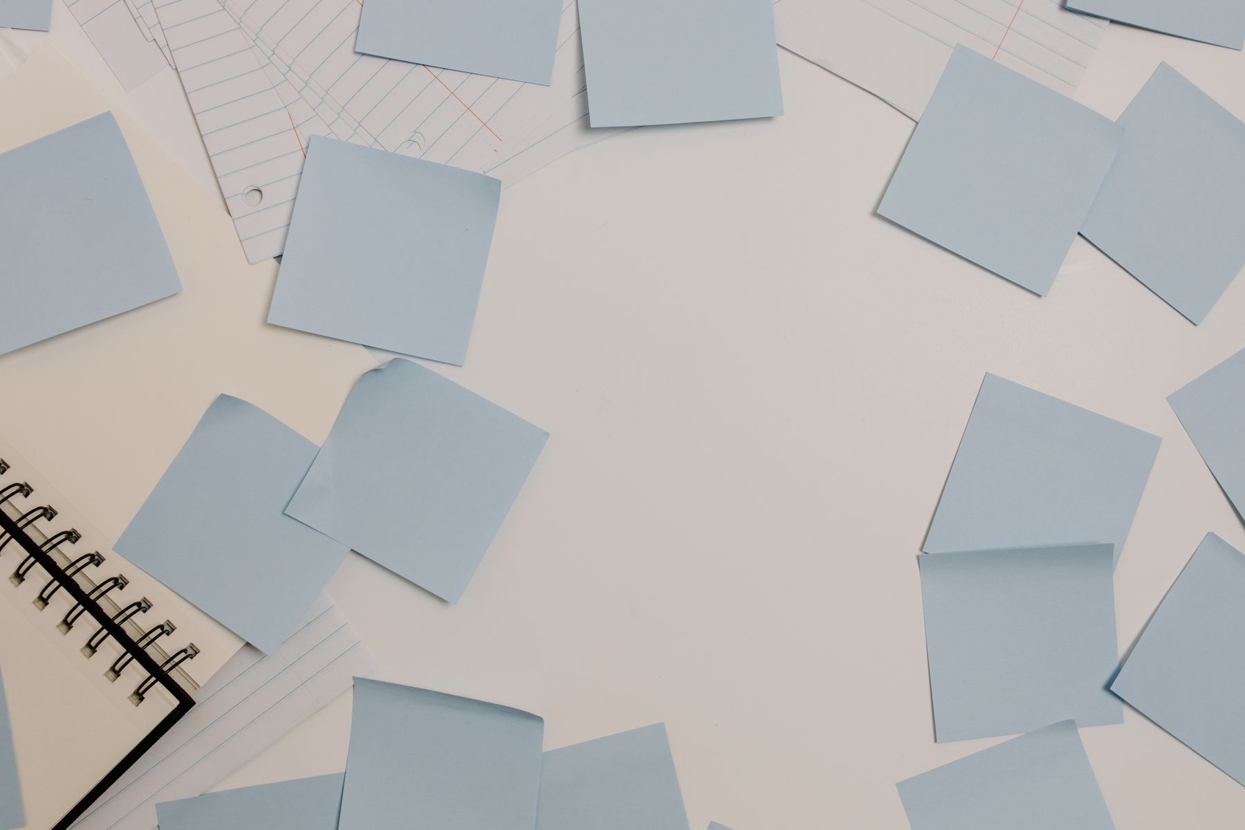 Planning desk arranged with blue sticky notes and a spiral notebook